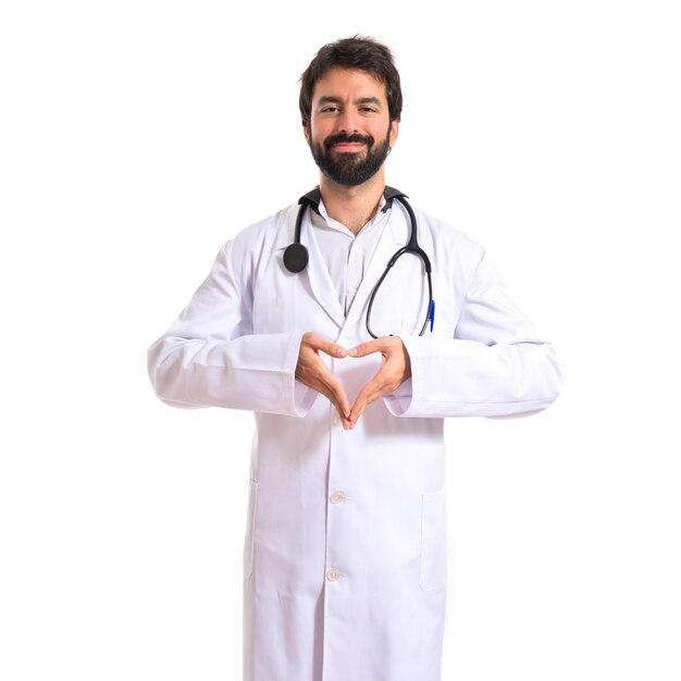 Doctor making a heart with her hands over white background