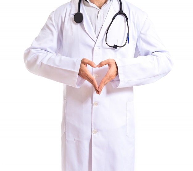 Doctor making a heart with her hands over white background