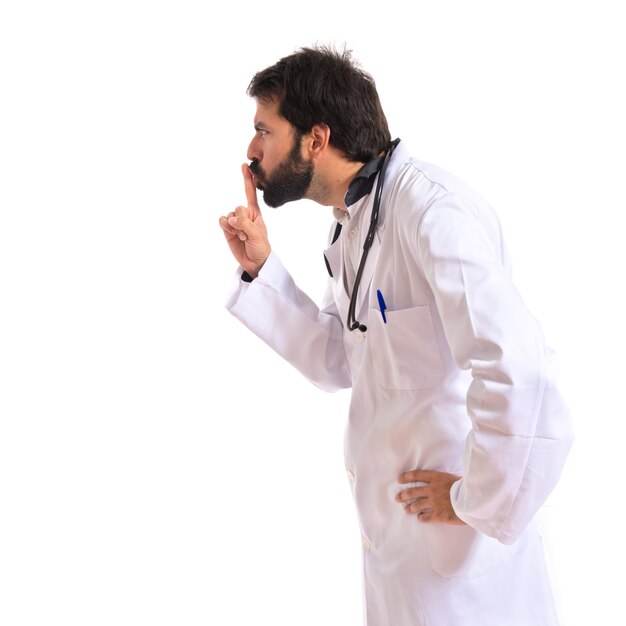 Doctor making silence gesture over isolated white background