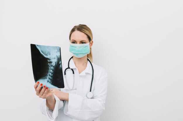 Doctor in mask examining X-ray picture