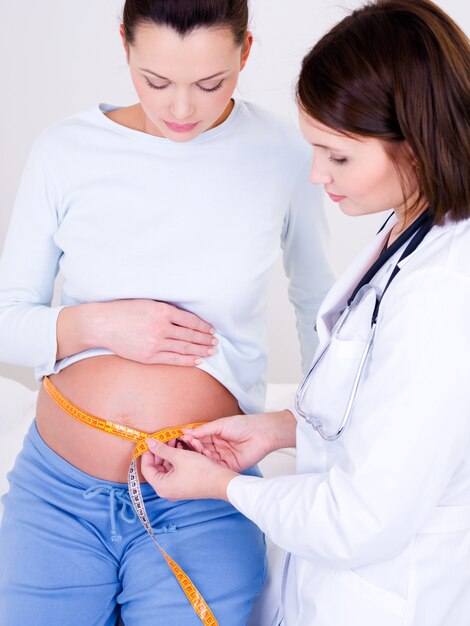 Doctor measuring a stomach at the pregnant woman