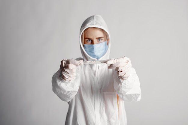 Foto gratuita dottore in una maschera medica. tema coronavirus. isolato su sfondo bianco. donna in una tuta protettiva.