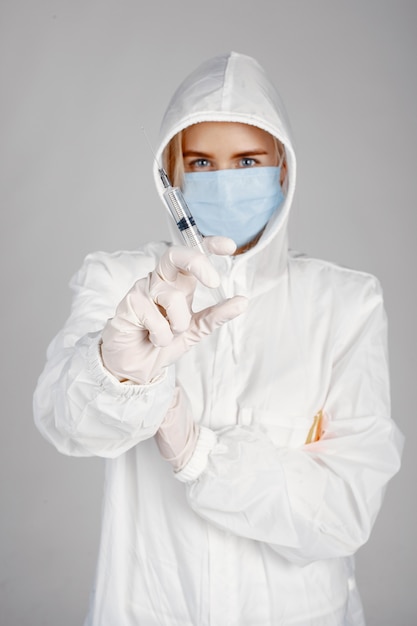 의료 마스크에 의사. 코로나 바이러스 테마. 흰색 배경 위에 격리. 보호 복에 여자입니다.