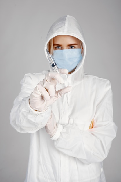 Doctor in a medical mask. Coronavirus theme. Isolated over white background. Woman in a protective suit.