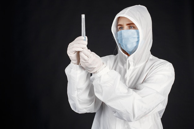 Doctor in a medical mask. Coronavirus theme. Isolated over white background. Woman in a protective suit.