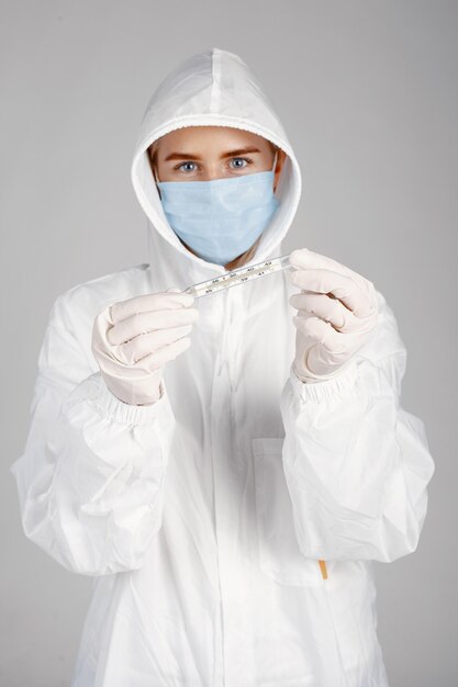 Doctor in a medical mask. Coronavirus theme. Isolated over white wall. Woman in a protective suit.