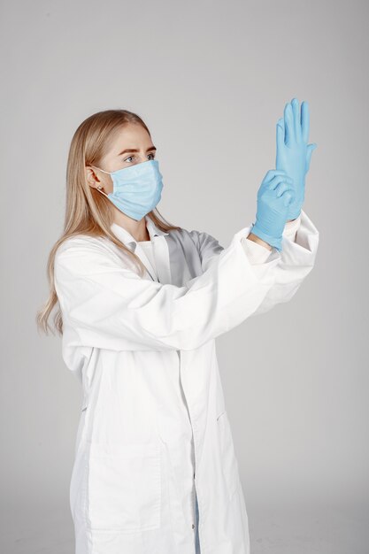 의료 마스크에 의사. 코로나 바이러스 테마. 흰 벽에 절연