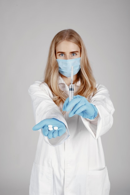 의료 마스크에 의사. 코로나 바이러스 테마. 흰 벽에 절연