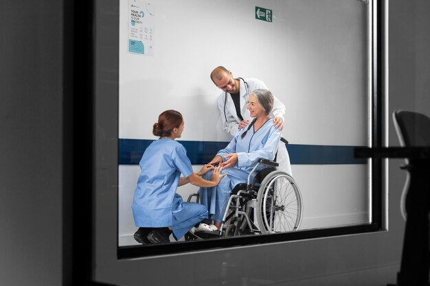 Doctor and nurse helping patient in wheelchair