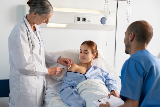 Free photo doctor and nurse helping woman medium shot