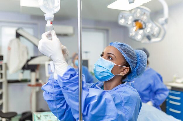 Врач в операционной вводит лекарства через концепции внутривенной хирургии