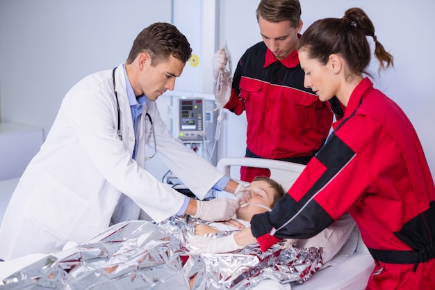 Free photo doctor and paramedic examining a patient in emergency room