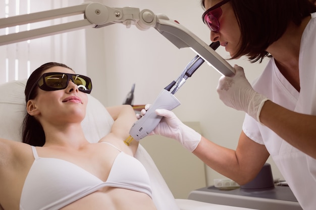 Free photo doctor performing laser hair removal on patient skin