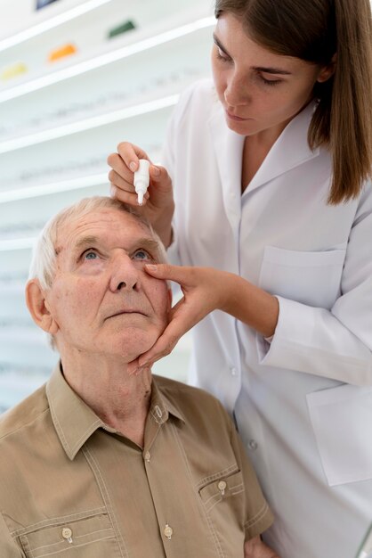 doctor pouring some eye drops for a patient