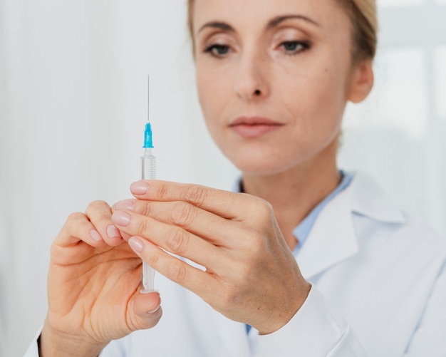 Free photo doctor preparing syringe for injection