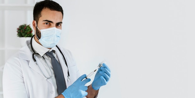 Free photo doctor preparing a vaccine with copy space