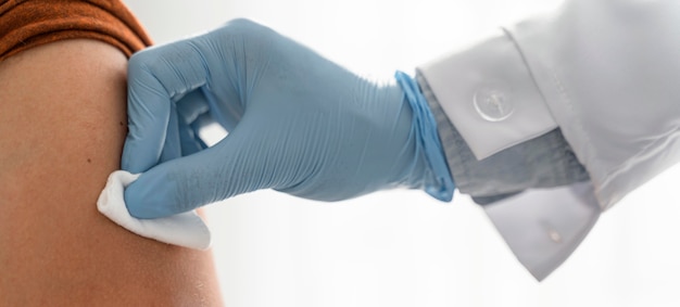 Doctor putting pressure on man's arm after vaccinating