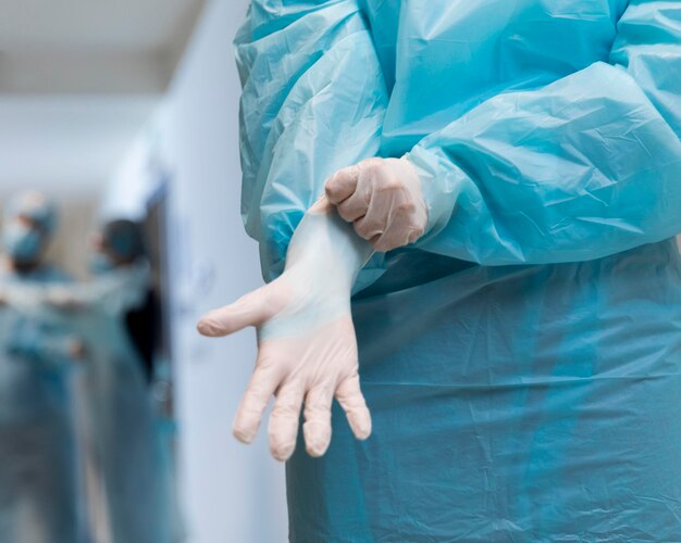 Доктор надевает хирургические перчатки крупным планом