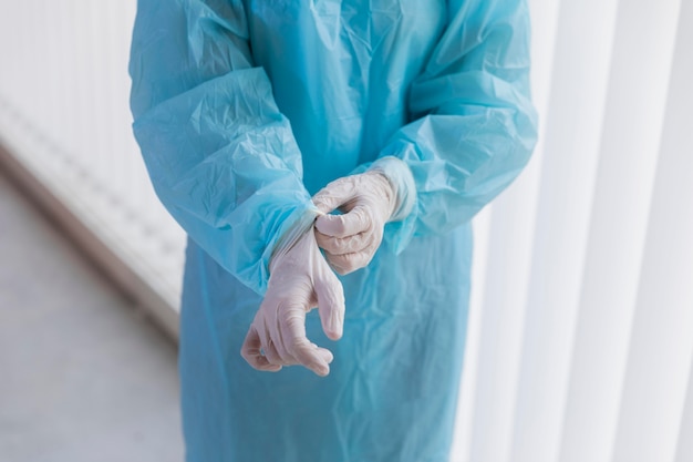 Free photo doctor putting on surgical gloves