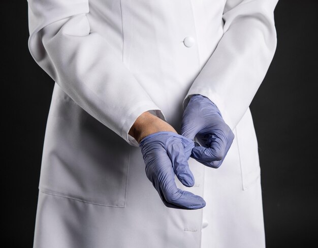 Doctor putting on surgical gloves