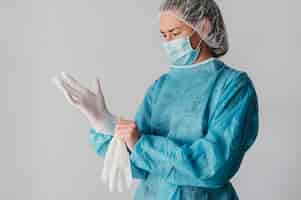Free photo doctor putting on surgical gloves