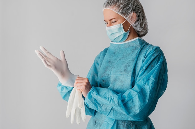 Doctor putting on surgical gloves