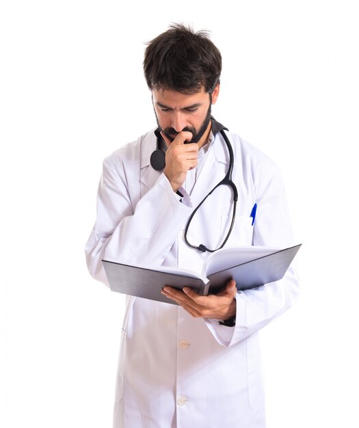 Doctor reading a book over white background