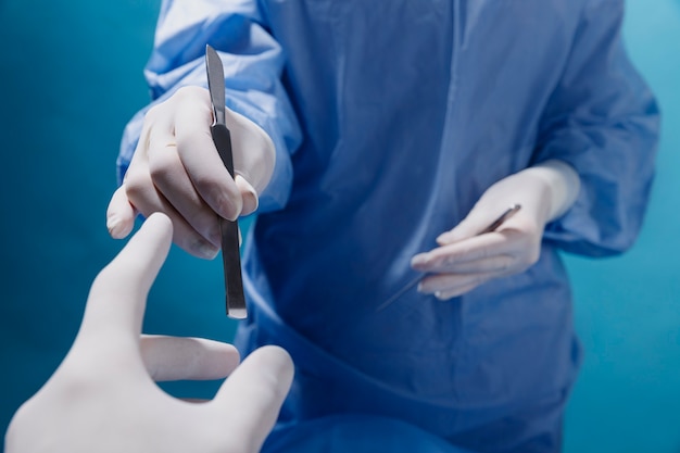 Doctor receiving medical scalpel during operation