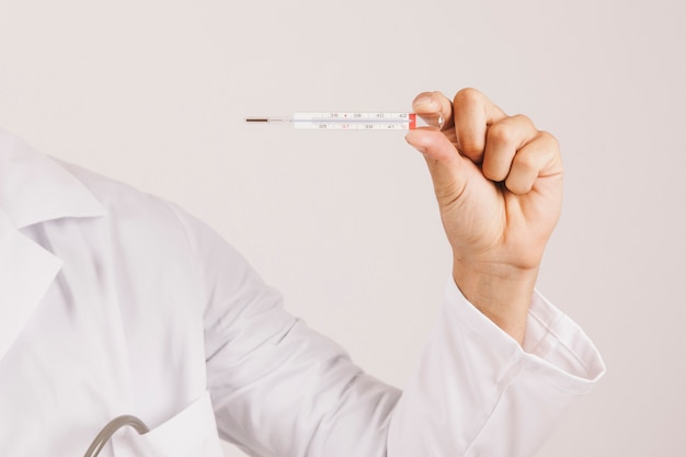 Doctor's hand holding a thermometer