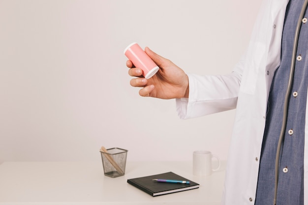 Free photo doctor's hand with a medication in the office