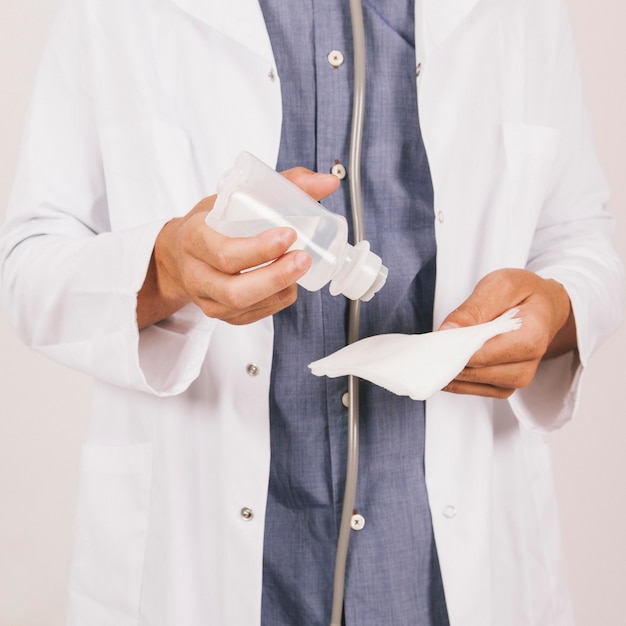 Foto gratuita le mani del medico con alcool e garza