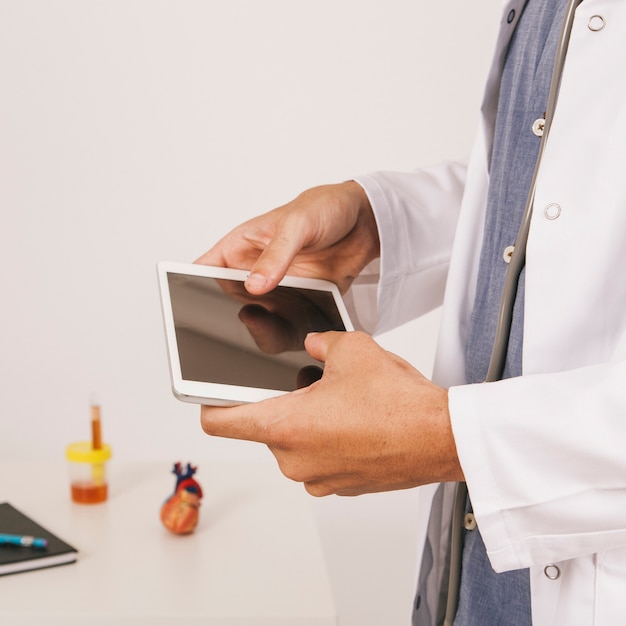 Foto gratuita le mani del medico lavorano con il tablet