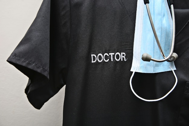 A Doctor's scrubs, stethoscope and face mask.