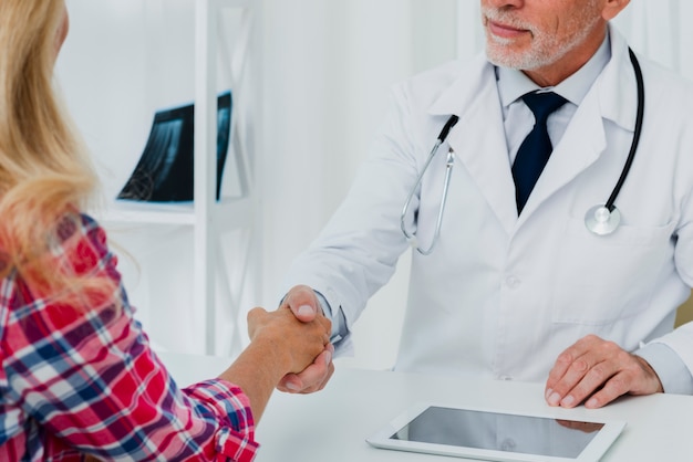 Free photo doctor shaking hand of patient