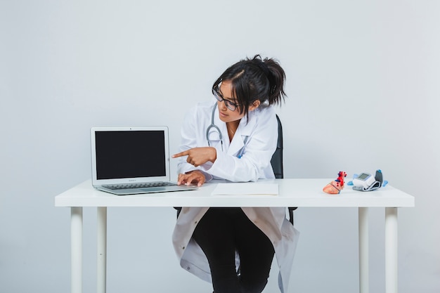 Free photo doctor showing laptop's screen