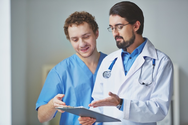 Doctor showing a prescription to a teammate