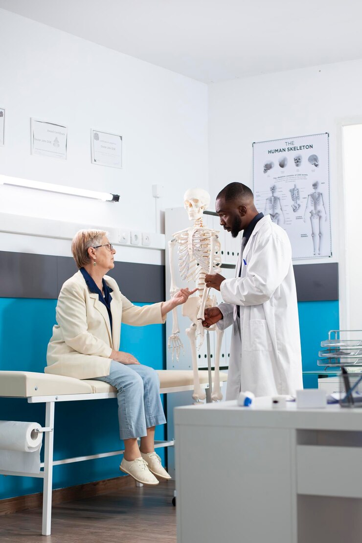 Free Photo doctor showing skeleton to retired woman