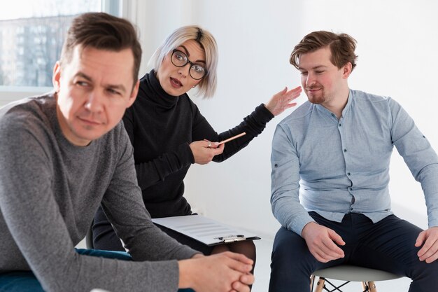 Doctor sitting between male patients