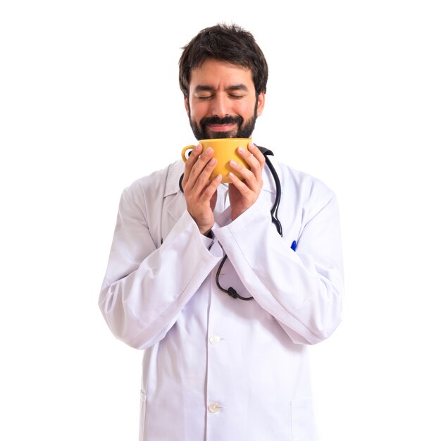 Doctor smelling coffee over white background