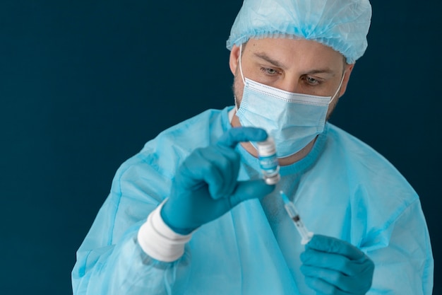 Doctor in special equipment holding the covid 19 vaccine