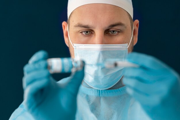 Doctor in special equipment holding the covid 19 vaccine