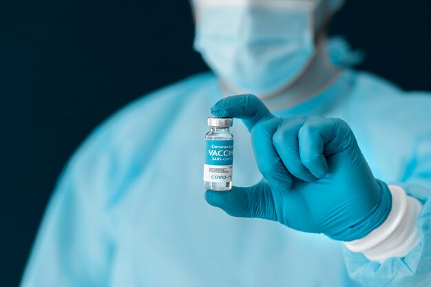 Doctor in special equipment holding the covid 19 vaccine