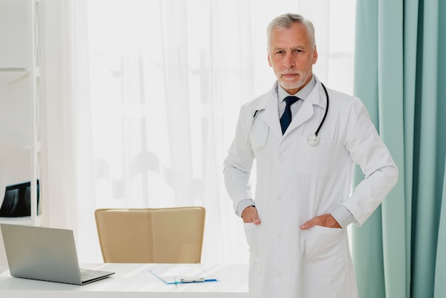 Doctor standing by desk with hands in pocket