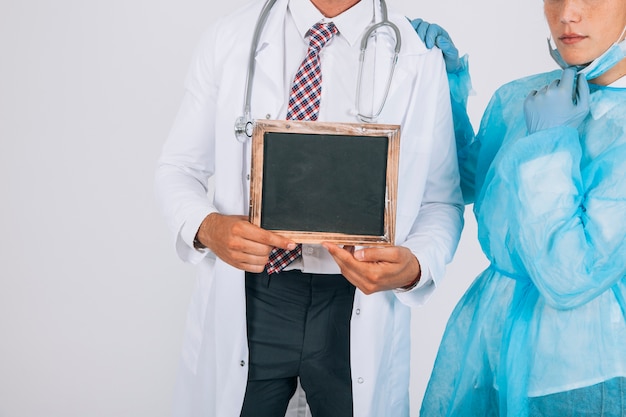 Doctor and surgeon holding a blackboard