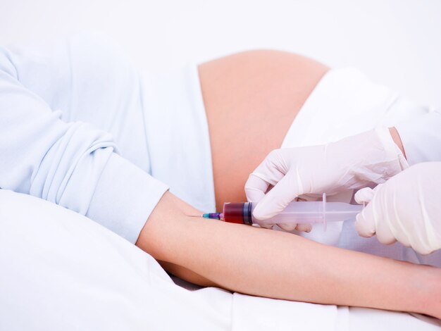 Врач берет кровь на анализ у беременной