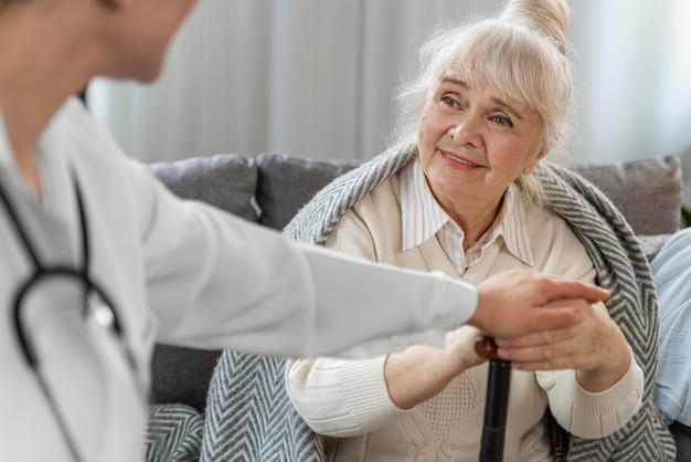 Free photo doctor taking care of senior woman at home