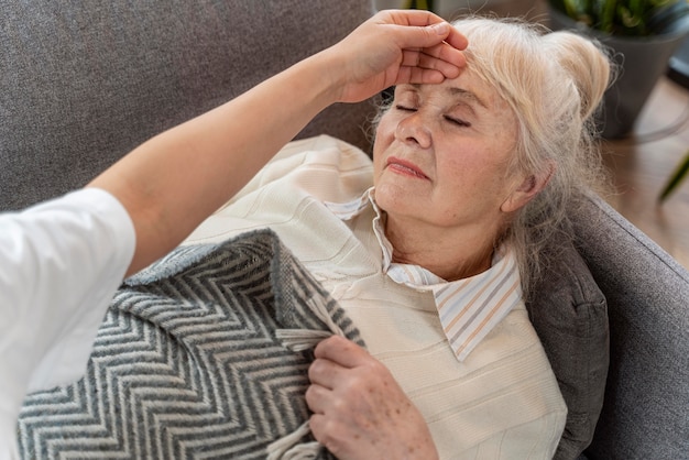 Doctor taking care of senior woman at home