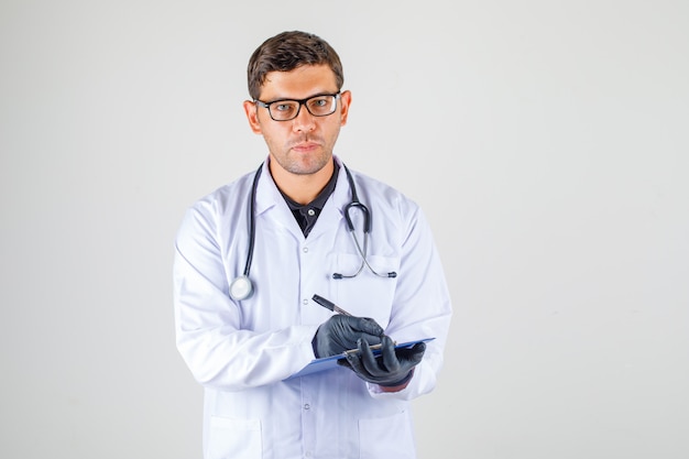 Doctor taking notes in medical white robe