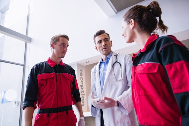 Doctor talking to paramedic in corridor