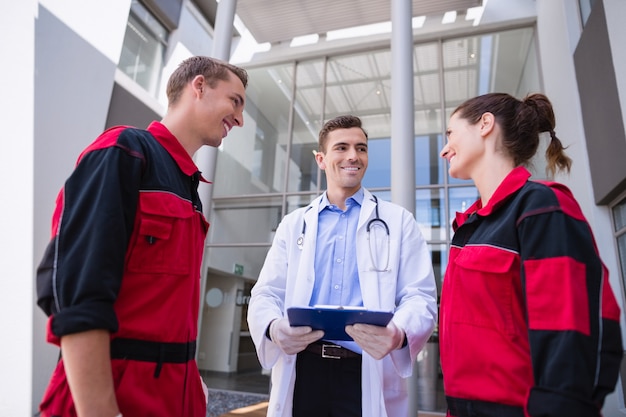 Doctor talking to paramedic in corridor